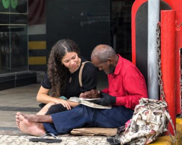 Jovem lê para idoso em situação de rua e cena emociona